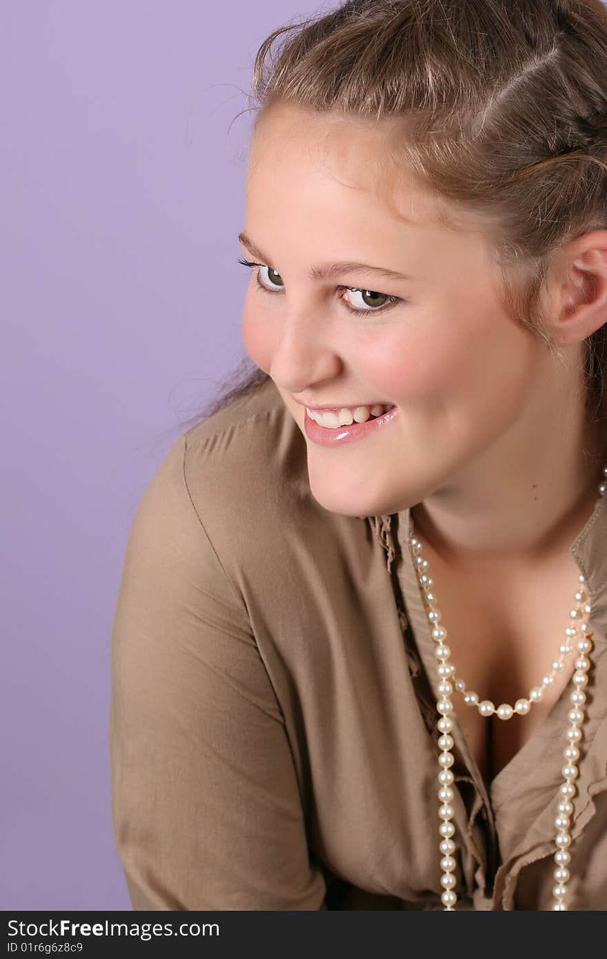 Beautiful teenage female against purple background, wearing pearls. Beautiful teenage female against purple background, wearing pearls