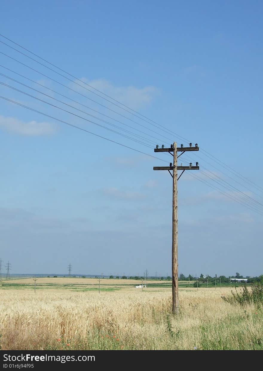 A lonely telegraph pole stands on the land and the blue sky is its only background