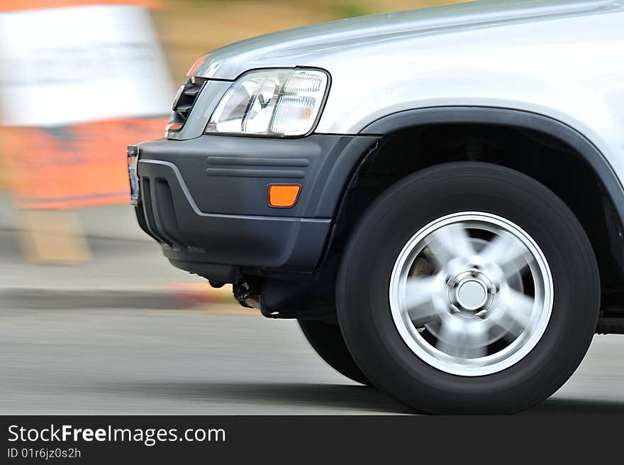 Wheel of automobile in motion. Car moving, but in focus, street and whell blurred. Wheel of automobile in motion. Car moving, but in focus, street and whell blurred