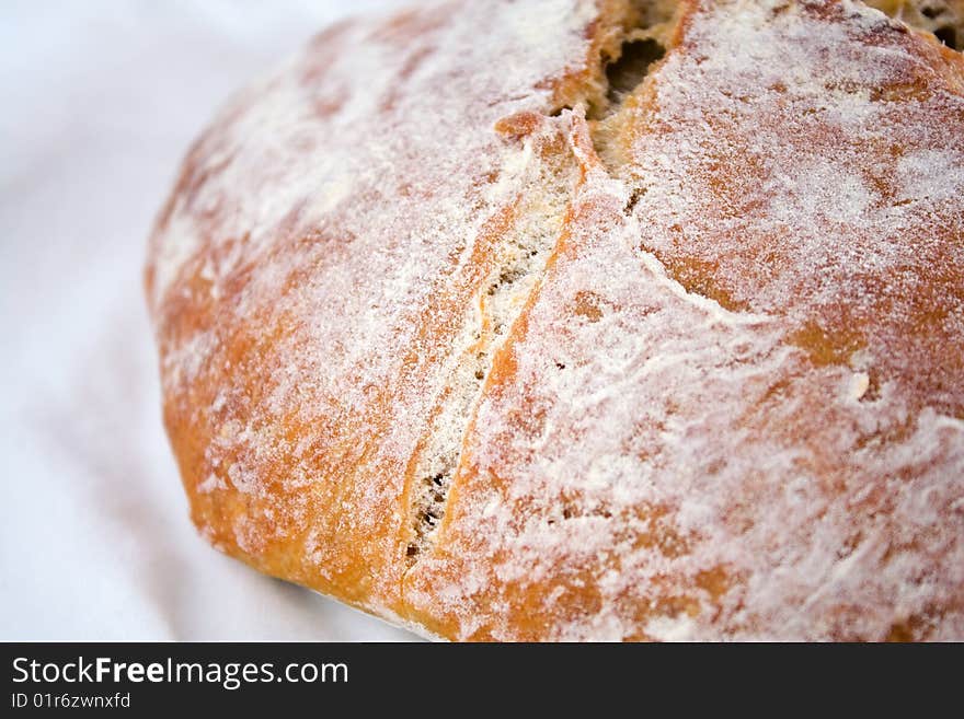 Closeup of fresh-baked whole-wheat bread on a white cotton cloth. Closeup of fresh-baked whole-wheat bread on a white cotton cloth.