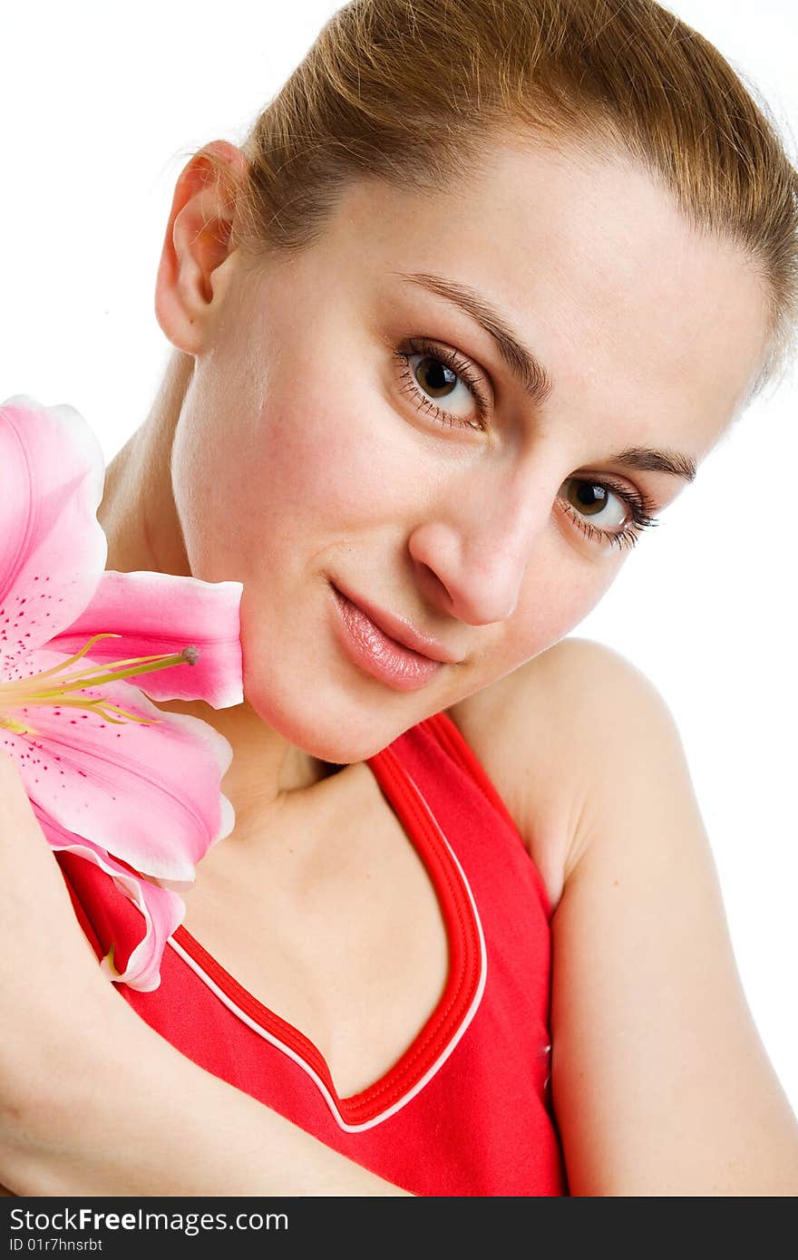 A portrait of a nice blond girl in red with a pink lily near her face on a white background. A portrait of a nice blond girl in red with a pink lily near her face on a white background