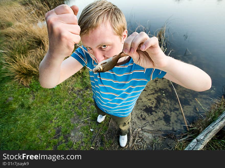 A cute guy showing a fish. A cute guy showing a fish