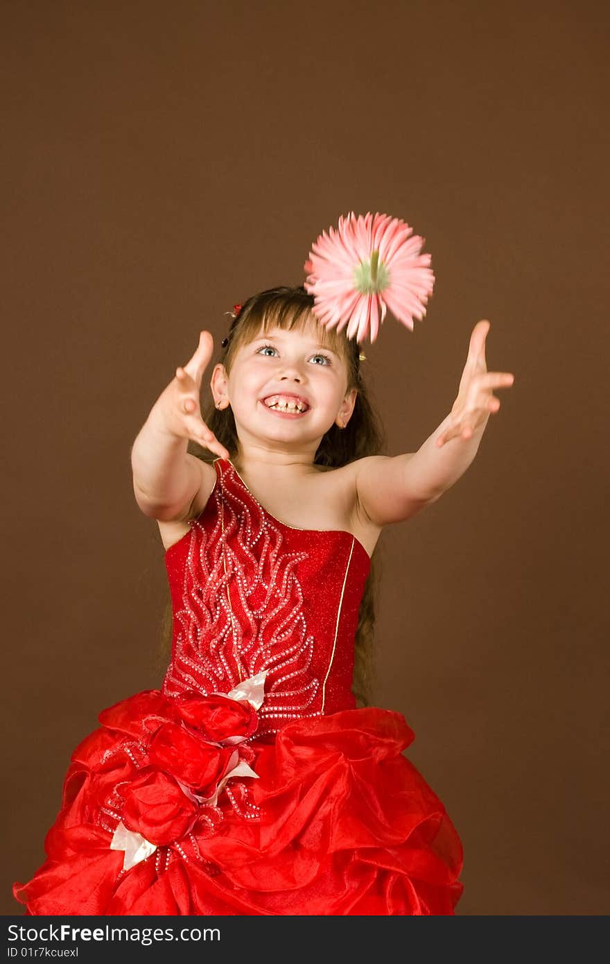 A beautiful girl in a red dress with a flower. A beautiful girl in a red dress with a flower