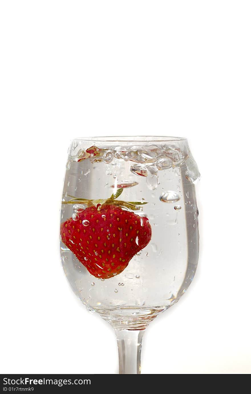 Strawberry in the clear water on white background in the glass. Strawberry in the clear water on white background in the glass