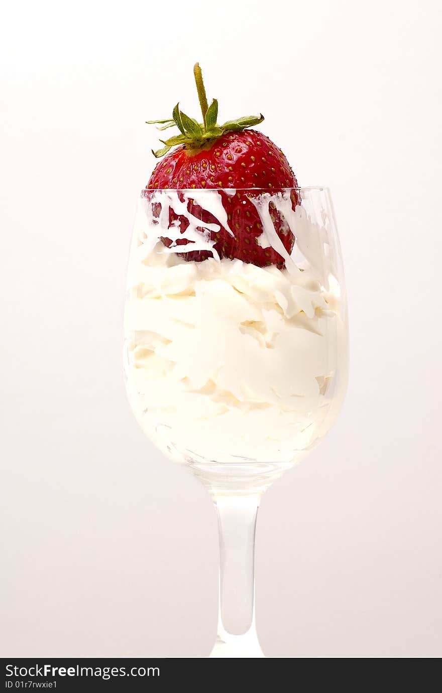 Red fresh strawberry on the whipped-cream in the glass on white. Red fresh strawberry on the whipped-cream in the glass on white