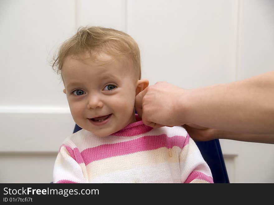 Cute baby sitting on baby chair and smile to camera