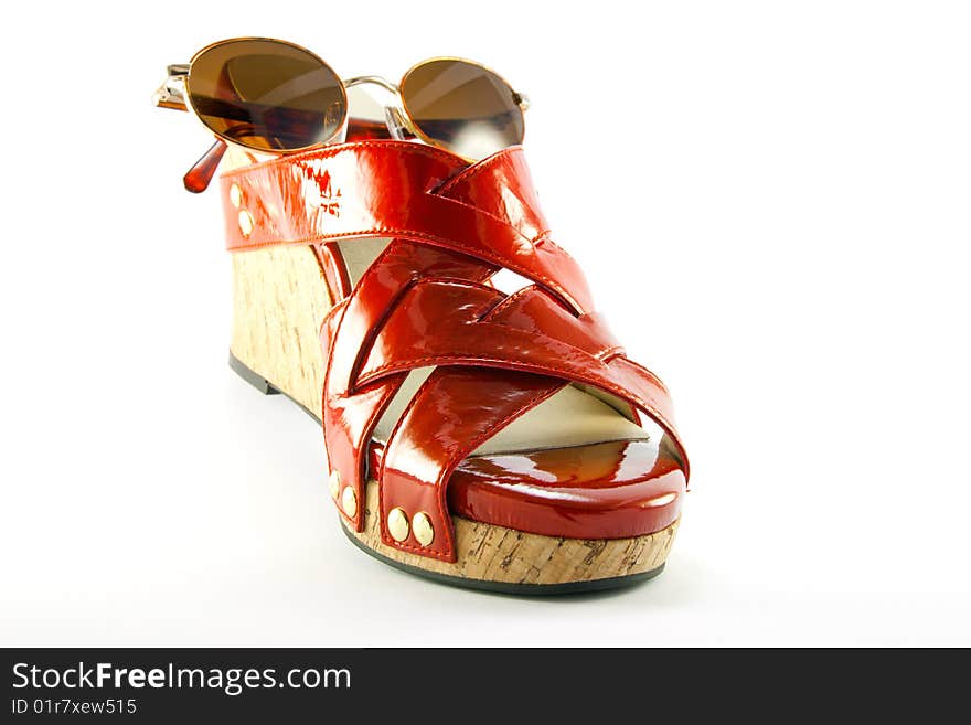 Single red shoe and brown sunglasses with clipping path on a white background. Single red shoe and brown sunglasses with clipping path on a white background