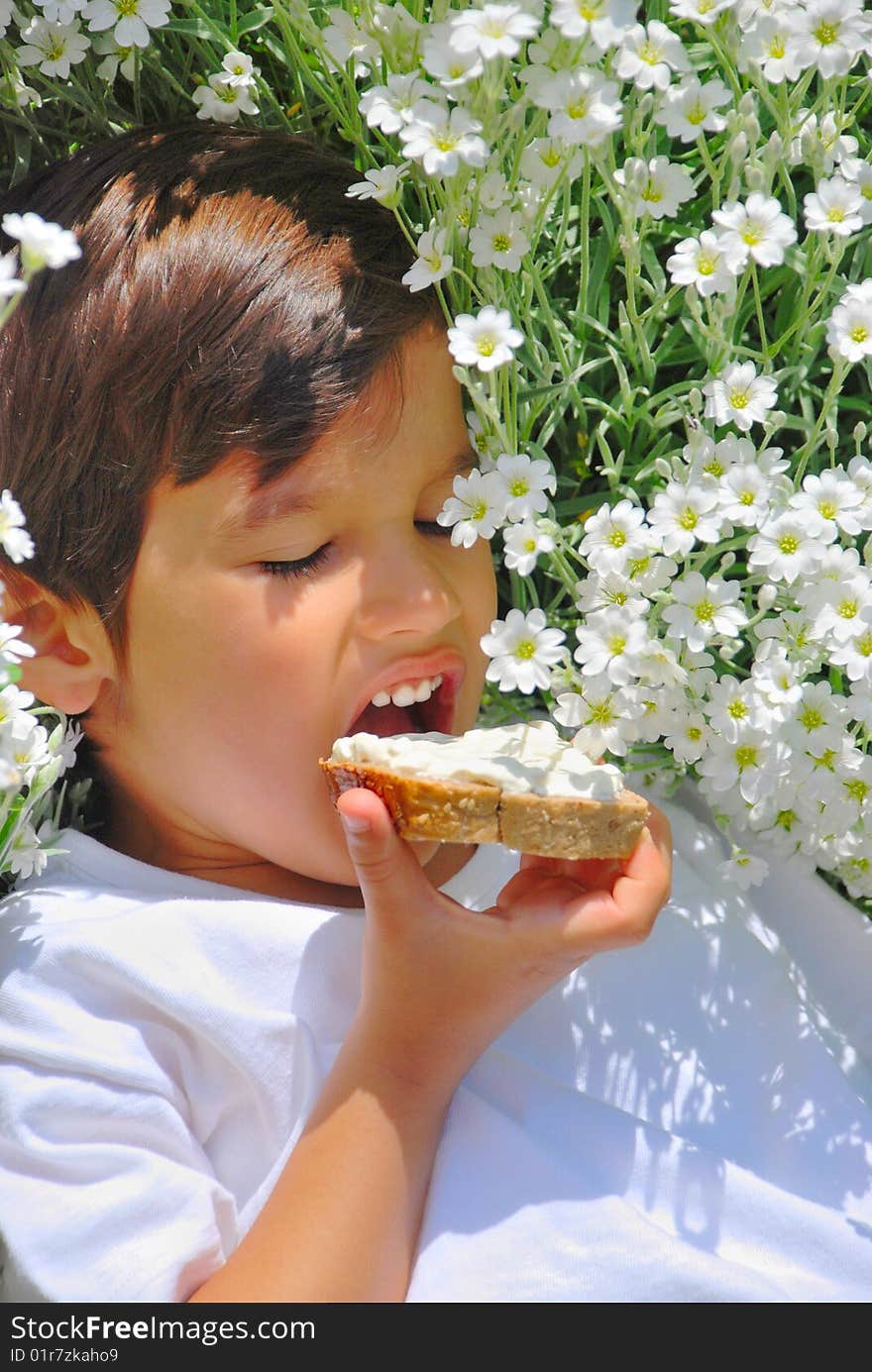 A little kid holding bread with white cream on. A little kid holding bread with white cream on