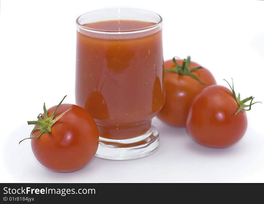 Glass of tomato juice and tomatoes on a white background