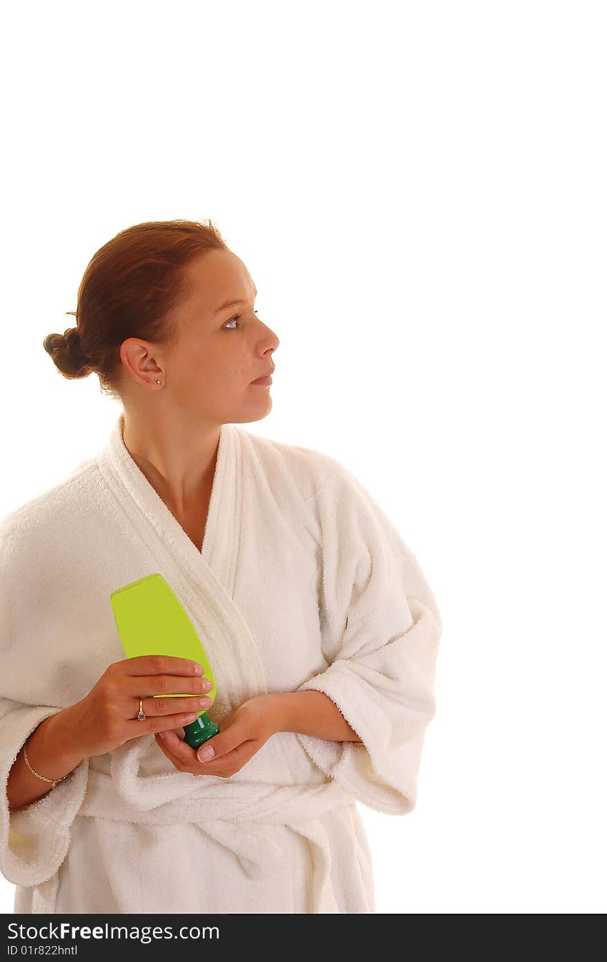 A young woman in an bad robe putting lotion after the shower on her face, for white background. A young woman in an bad robe putting lotion after the shower on her face, for white background.