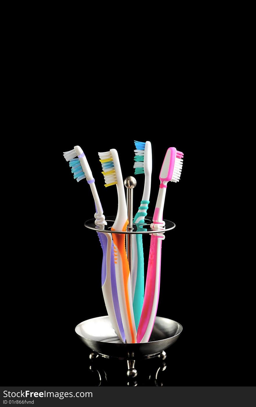 Four colorful toothbrushes isolated on black