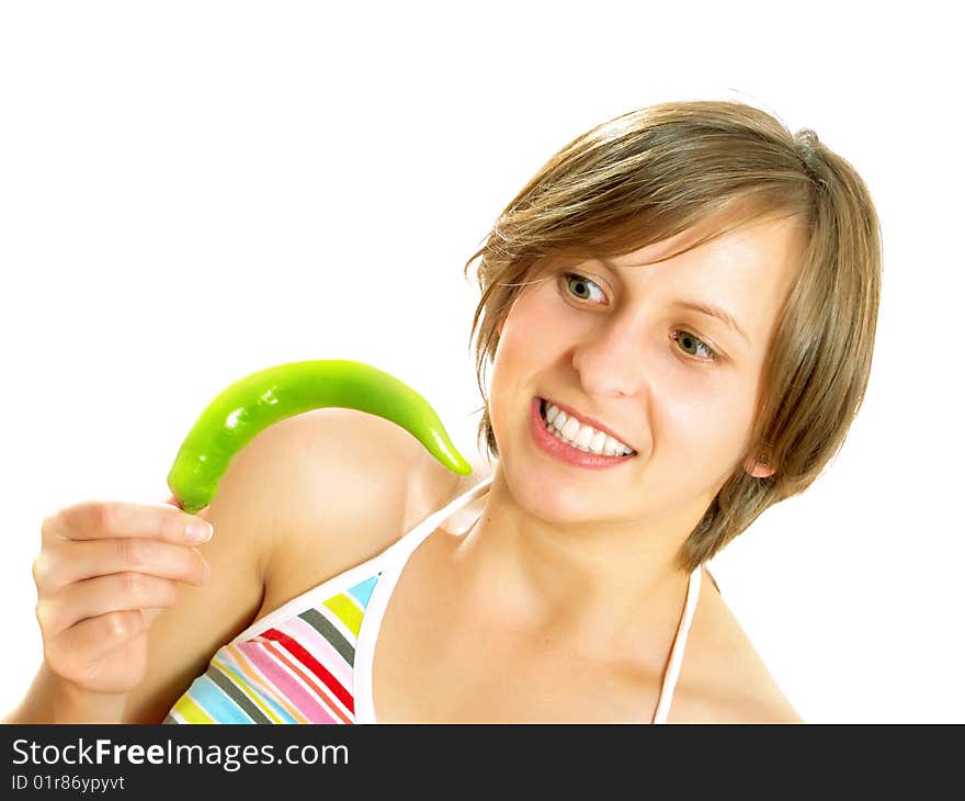 Portrait of a young cute Caucasian blond girl with a nice colorful striped summer dress who is going crazy and she is holding a fresh green chilly pepper in her hand. Isolated on white. Portrait of a young cute Caucasian blond girl with a nice colorful striped summer dress who is going crazy and she is holding a fresh green chilly pepper in her hand. Isolated on white.