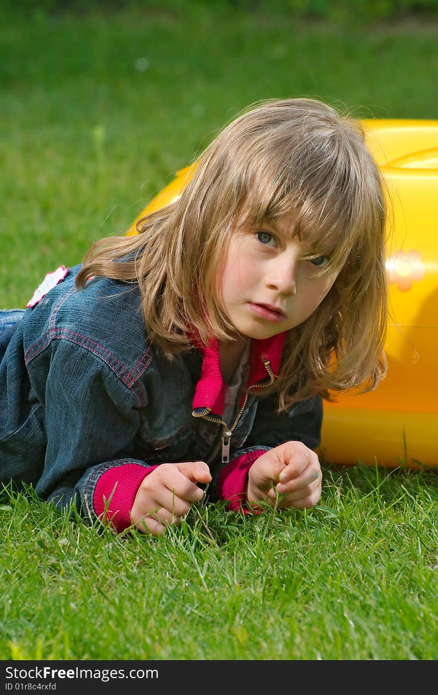 Young girl lies on the grass