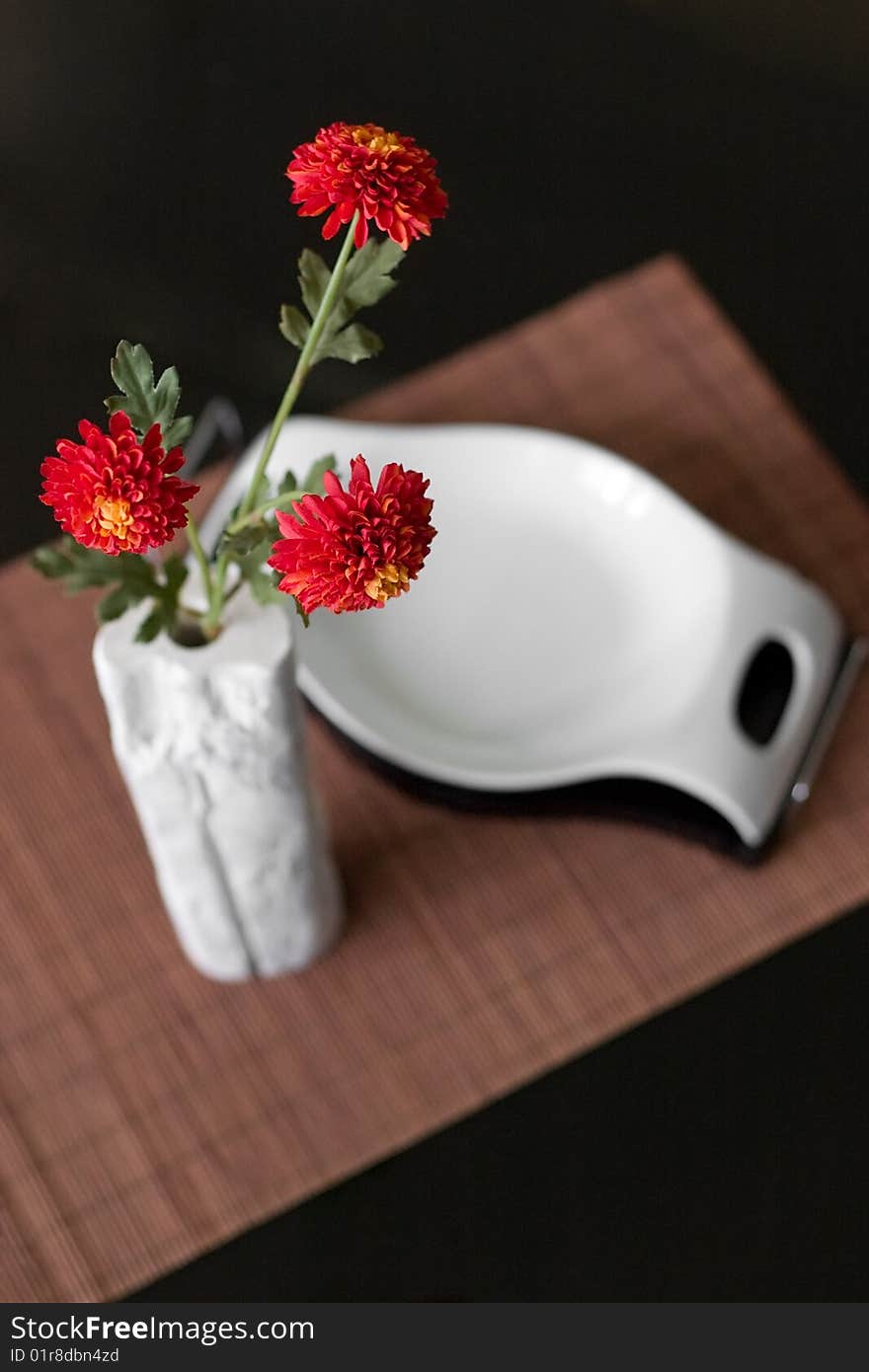 Interior detail of vase with red flowers and candy bowl