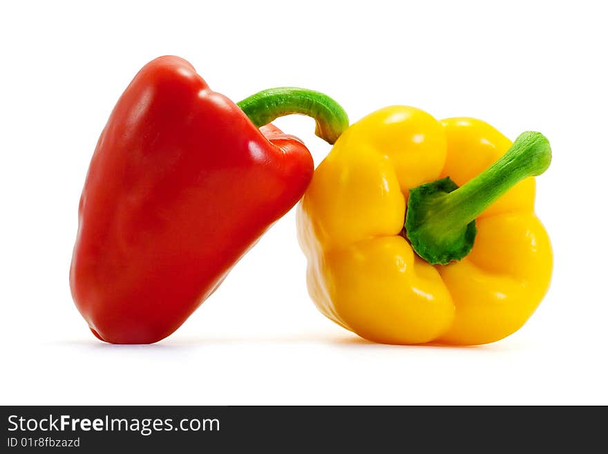 Yellow and red shiny ripe appetizing peppers on a white background. Yellow and red shiny ripe appetizing peppers on a white background