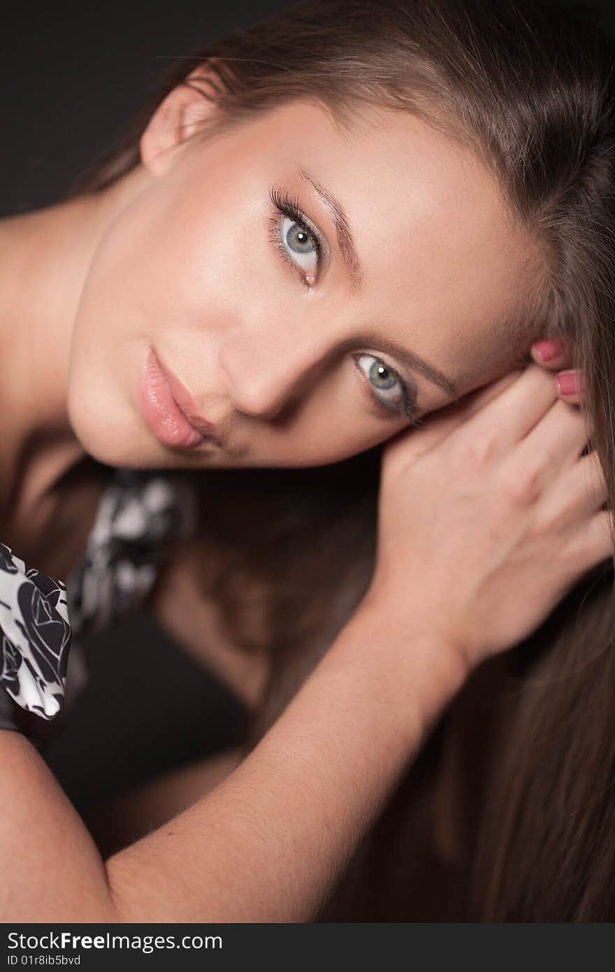 Portrait of attractive brown-haired girl touching her hair