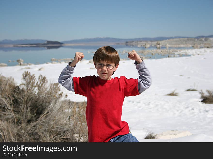 Boy showing his muscles in front of the Lake. Boy showing his muscles in front of the Lake