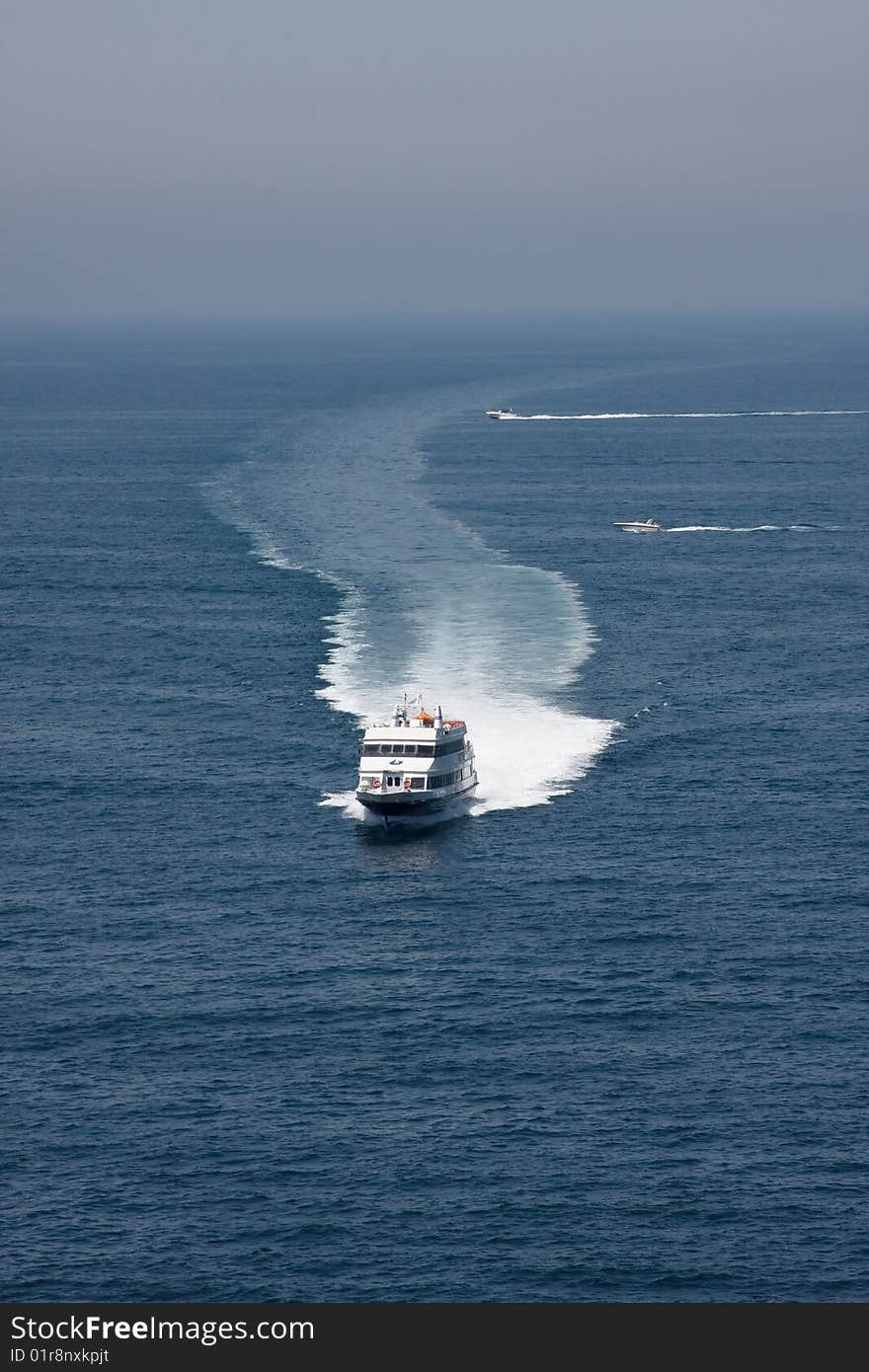 Boat leaving sea-foam trace. View at the sea.