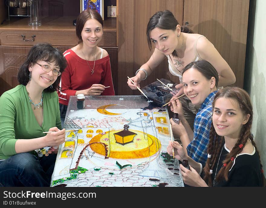 Friends drawing with vitrage dye and smiling. Friends drawing with vitrage dye and smiling