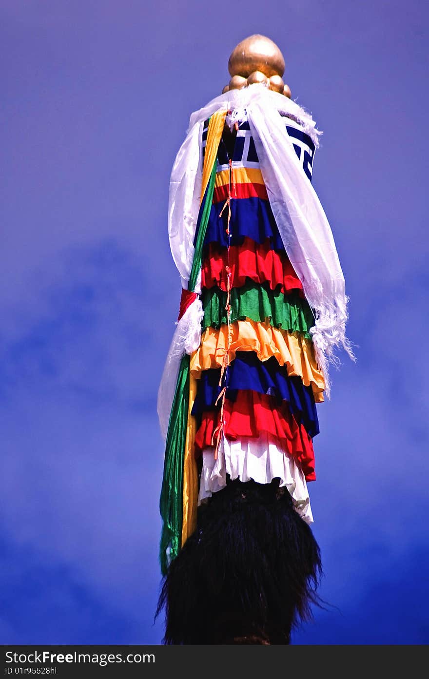 The flag of tibetan Buddhism with a shining golden top under sun shine. The flag of tibetan Buddhism with a shining golden top under sun shine