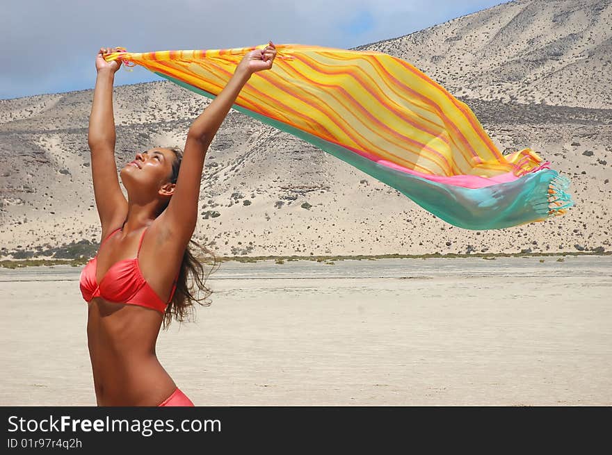 Woman in desert under the sun with scarf in her hands. Woman in desert under the sun with scarf in her hands