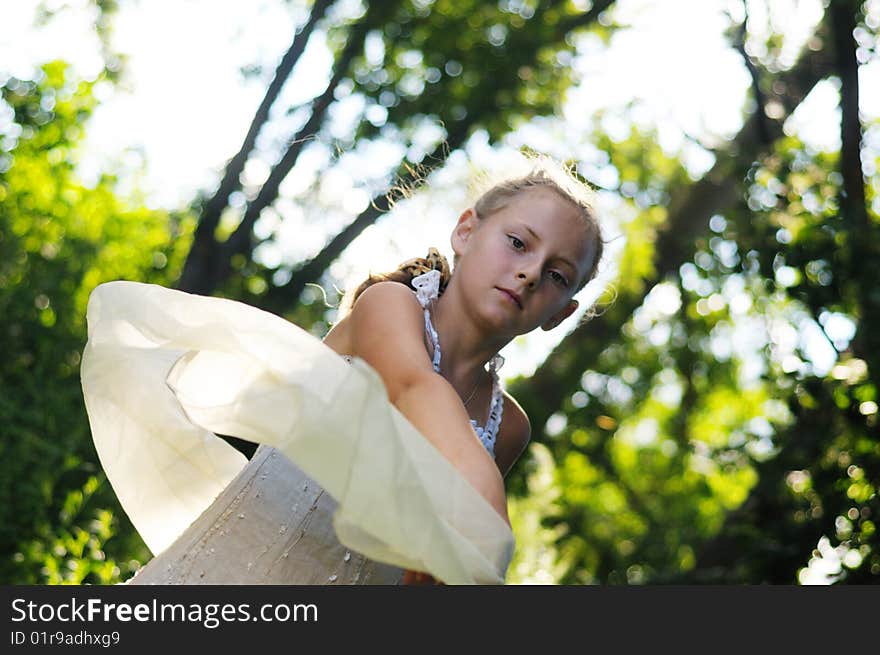 The girl in a beautiful dress poses against the nature