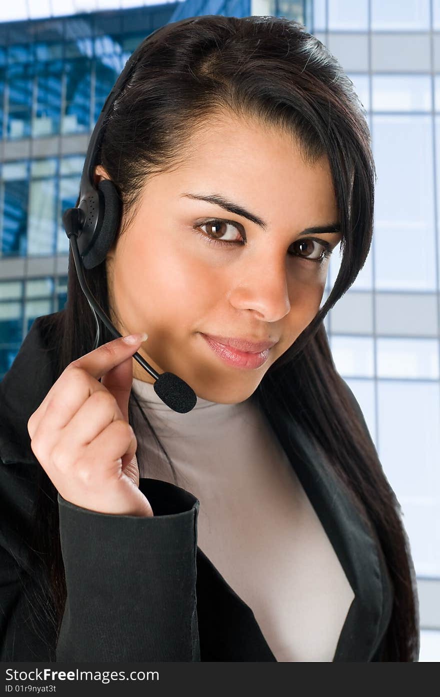 Young and smiling operator talking on the phone at the office. Young and smiling operator talking on the phone at the office