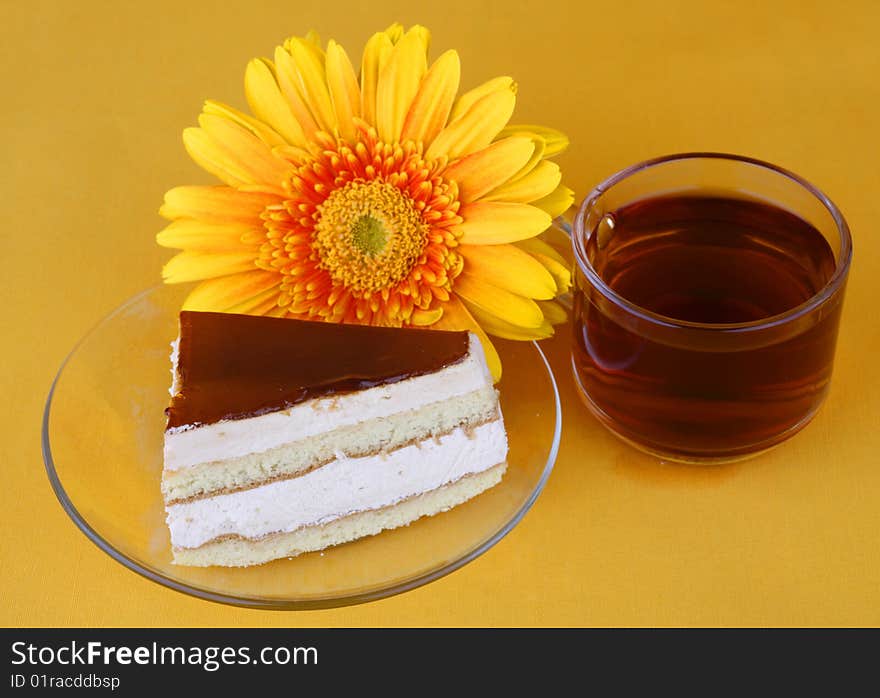 Cake with caramel on a yellow background and cup tea. Cake with caramel on a yellow background and cup tea