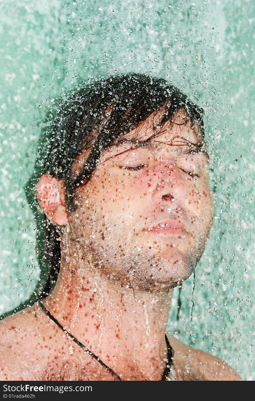 Young man standing under the water. Young man standing under the water