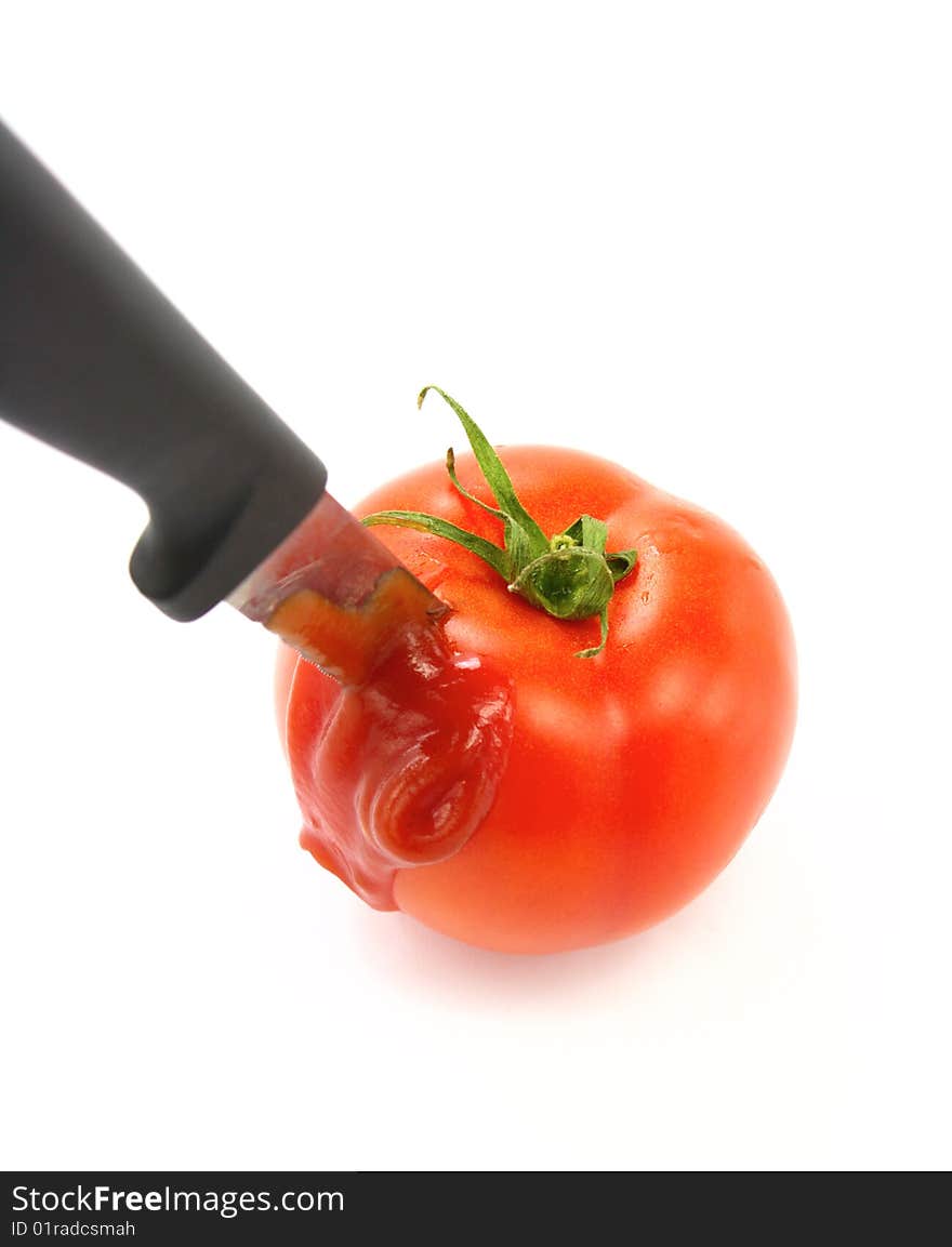 Tomato with knife on the white. Tomato with knife on the white