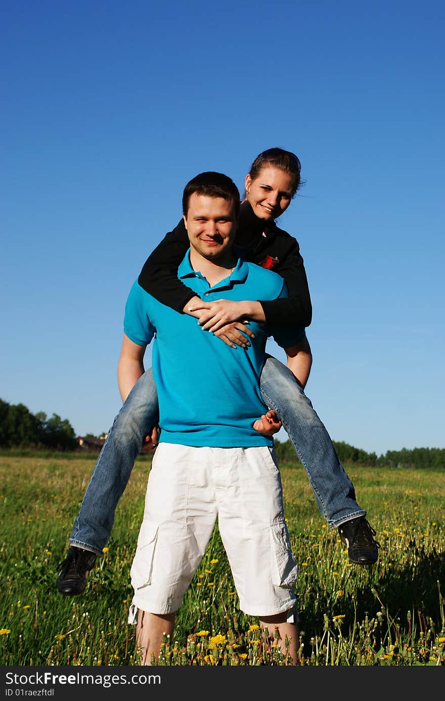 Happy couple playing in the sunny field. Happy couple playing in the sunny field