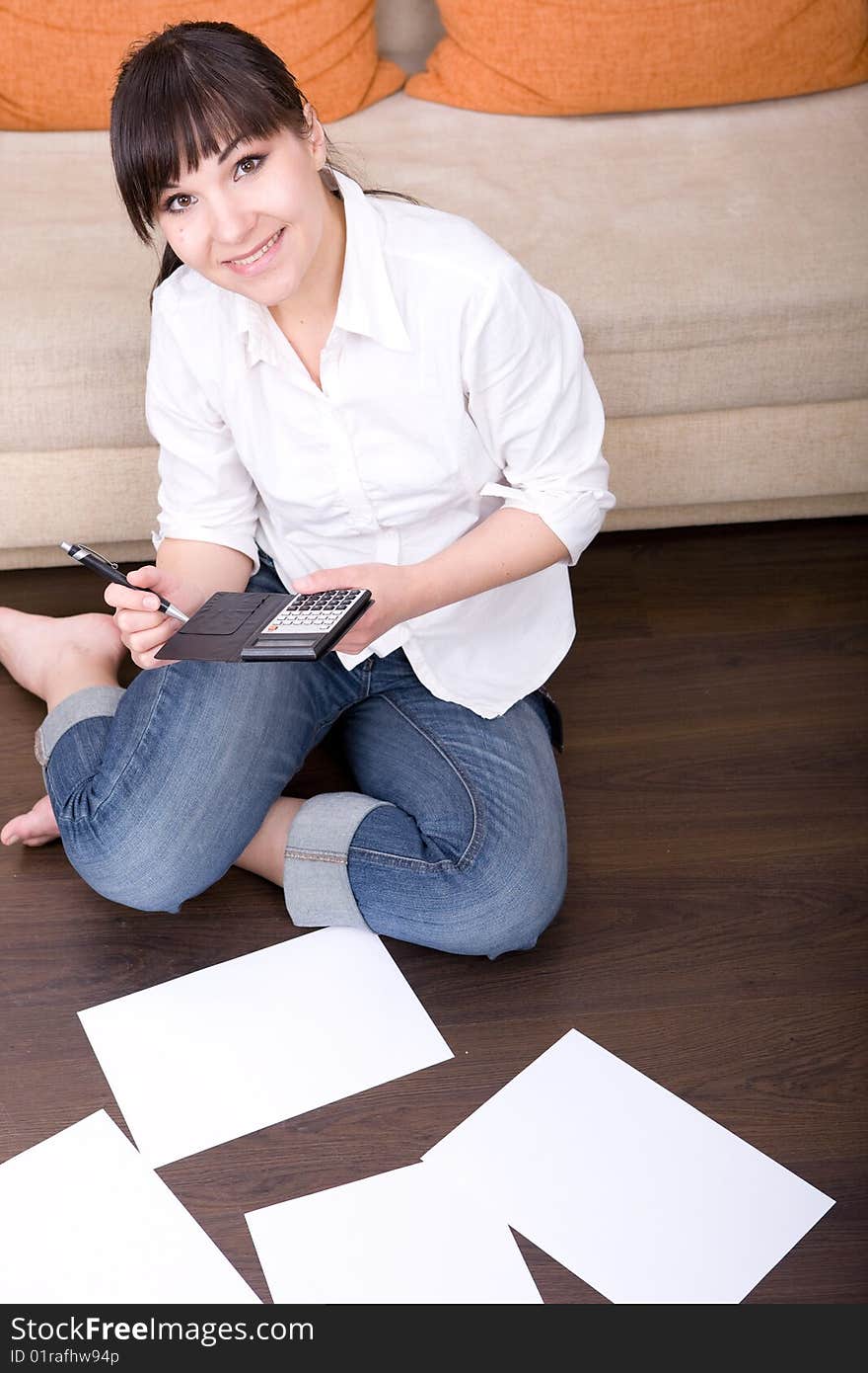 Happy young woman with calculator at home. Happy young woman with calculator at home