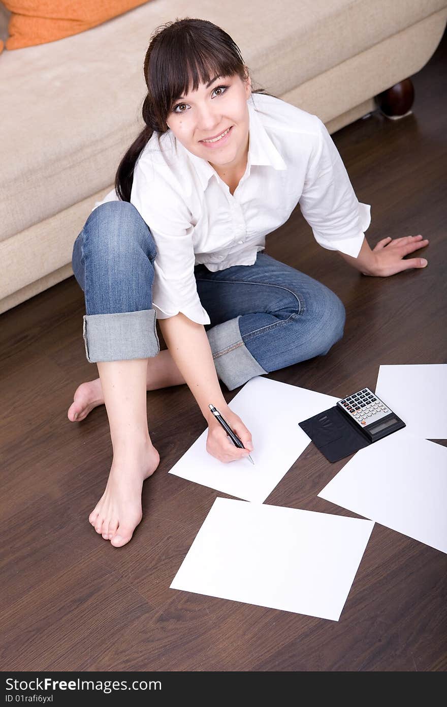 Happy young woman with calculator at home. Happy young woman with calculator at home