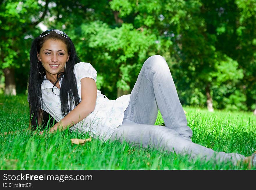 Beautiful girl laying on the green grass