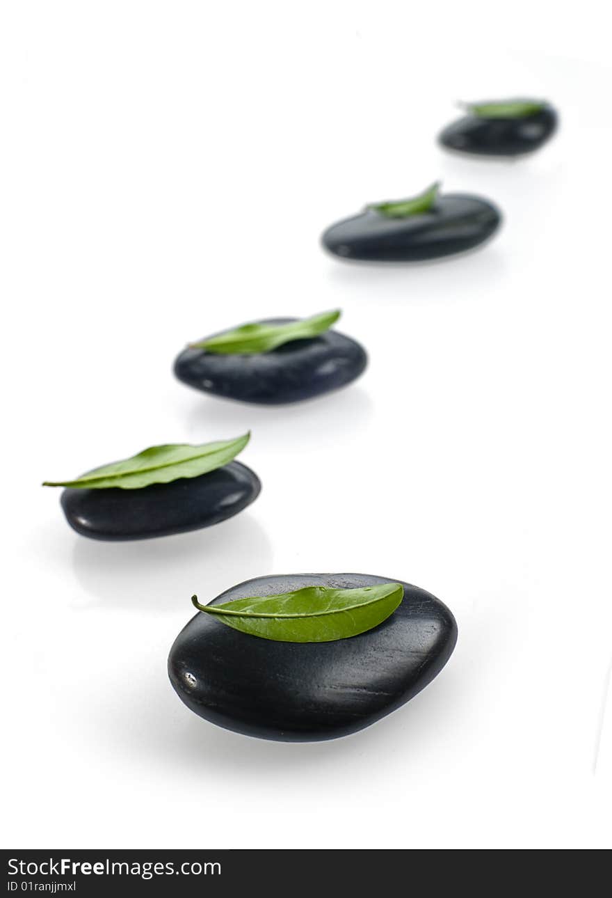 Black spa stones with shadows on a white background