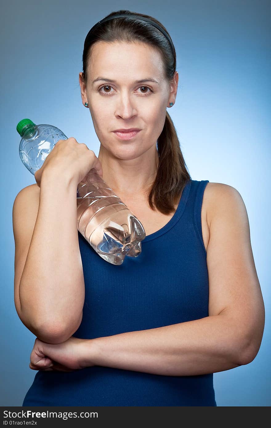 A young sporty woman with a bottle of mineral water. A young sporty woman with a bottle of mineral water.