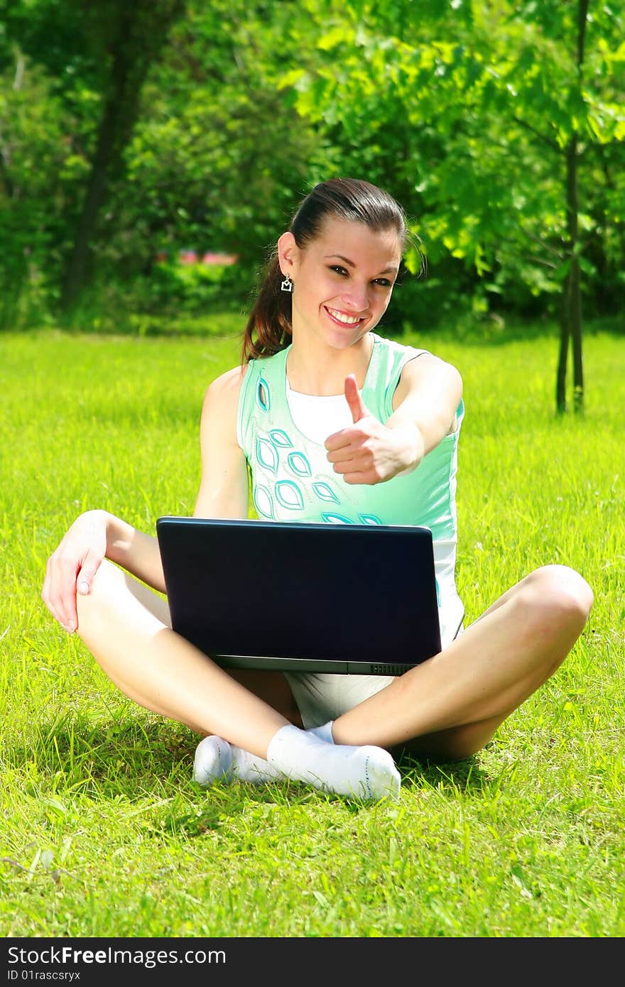 Young woman on a nature with the laptop