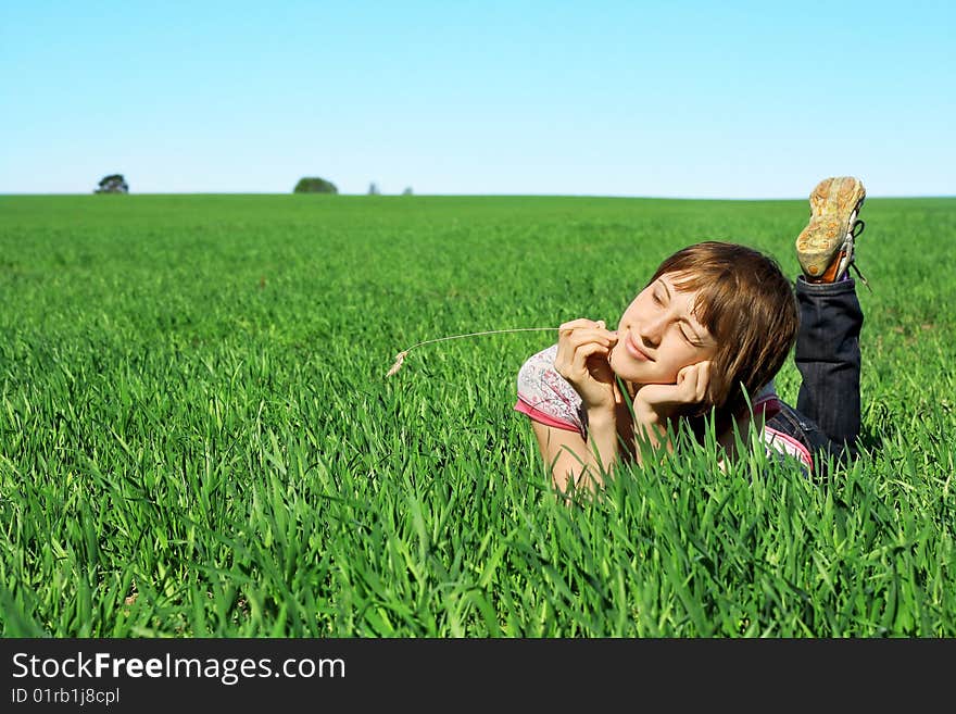 Young woman lying in green grass