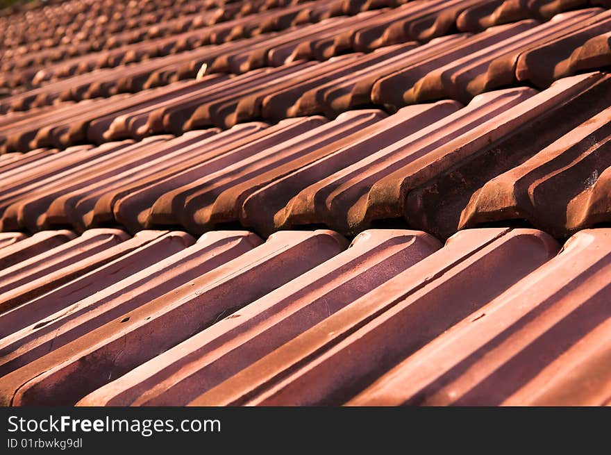 Old heavy cracked clay roof tiles on an abandoned building. Old heavy cracked clay roof tiles on an abandoned building