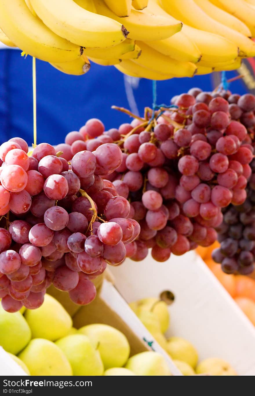 Fresh fruit on a market - grapes, banana and apples