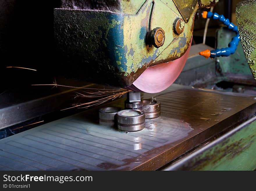 Filing down stainless steel parts using semi-automated machinery. Filing down stainless steel parts using semi-automated machinery