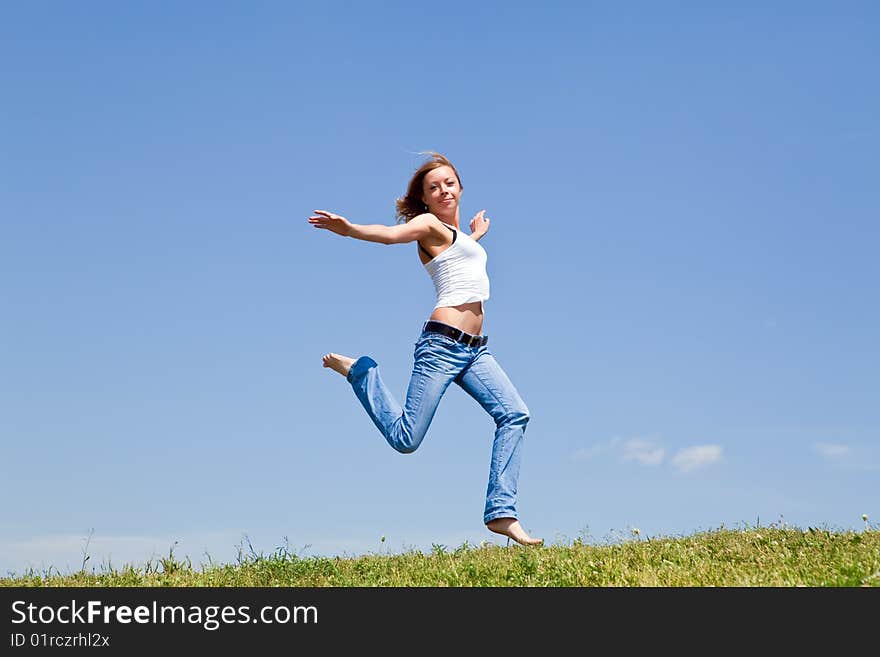 Girl run on a green grass against the blue sky. Girl run on a green grass against the blue sky