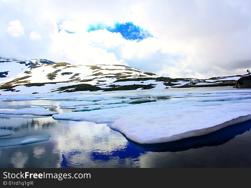 Andscape with winter lake under sky with clouds