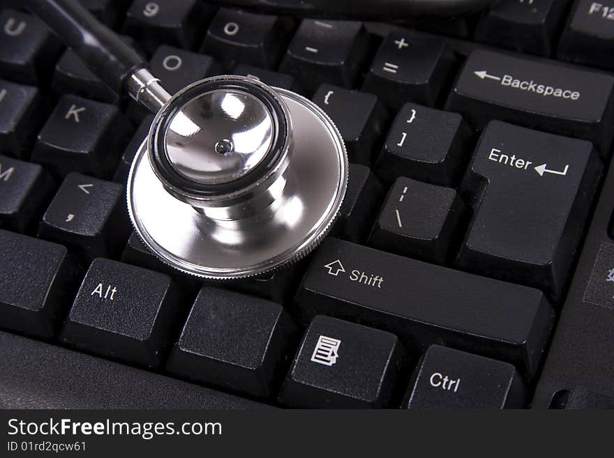 Black color computer keyboard with stethoscope on top. Black color computer keyboard with stethoscope on top.