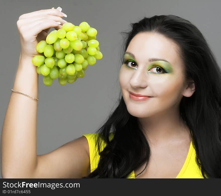 Portrait of young brunette with green grapes. Portrait of young brunette with green grapes