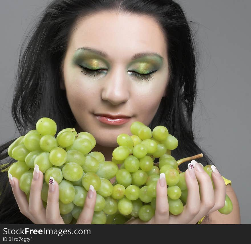 Portrait of young brunette with green grapes. Portrait of young brunette with green grapes