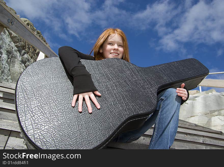 Tween girl holding guitar in its case. Tween girl holding guitar in its case