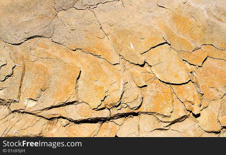 A strongly cracked yellow background of stone. A strongly cracked yellow background of stone