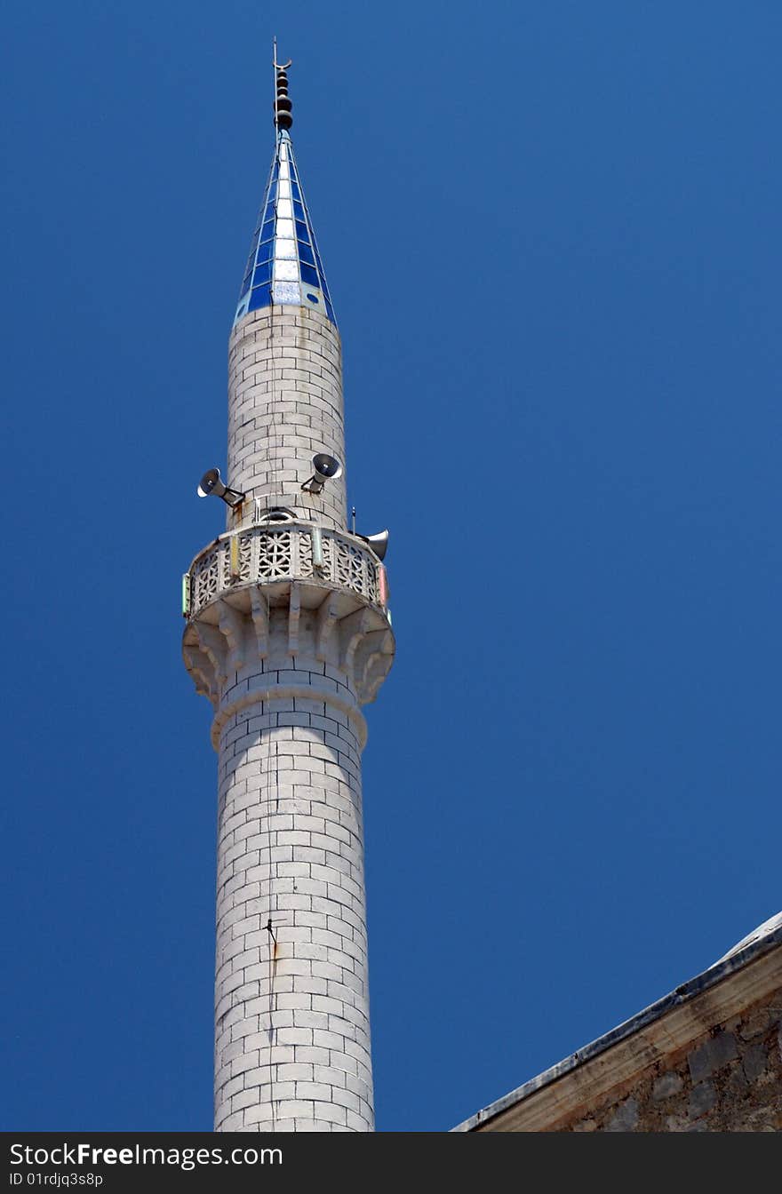 The minaret tower of a muslim mosque in turkey with a blue tip. Speakers for call to prayer. The minaret tower of a muslim mosque in turkey with a blue tip. Speakers for call to prayer.