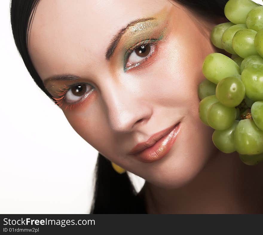 Beautiful young woman with green grape